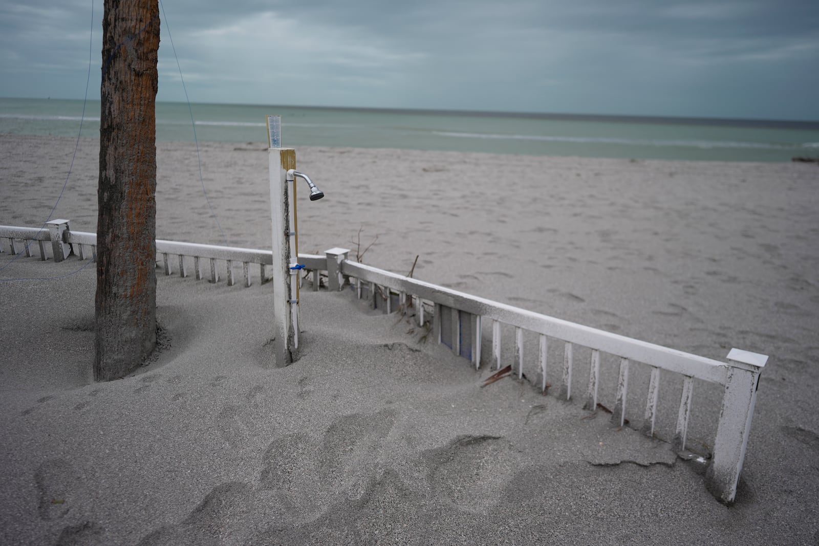 Displaced sand partially buries an outdoor shower and pool deck at Bahia Vista Gulf, following the passage of Hurricane Milton, on the island of Venice, Fla., Friday, Oct. 11, 2024. (AP Photo/Rebecca Blackwell)