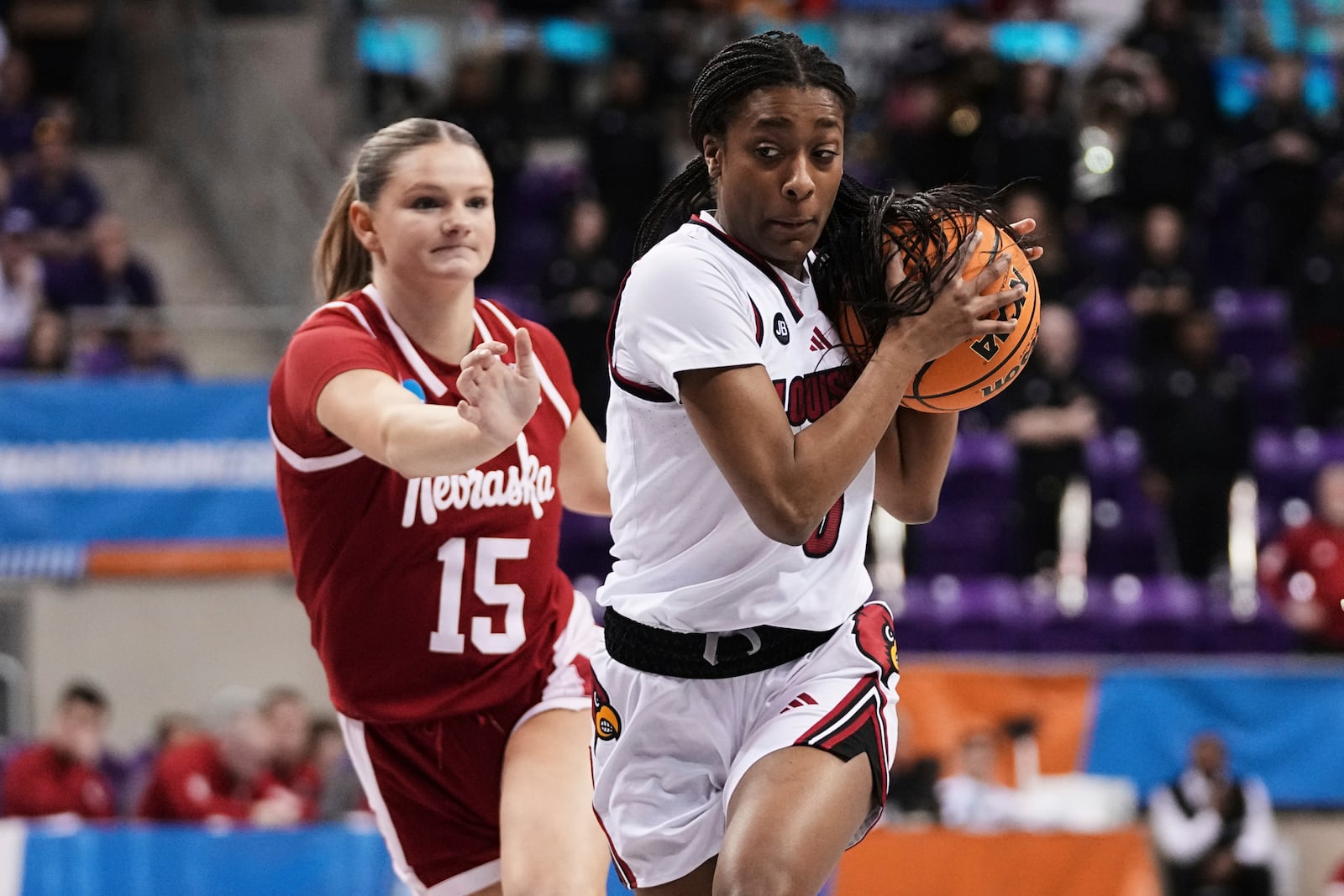 Louisville's Izela Arenas, right, drives to the basket as Nebraska's Kendall Moriarty (15) defends in the first half in the first round of the NCAA college basketball tournament in Fort Worth, Texas, Friday, March 21, 2025. (AP Photo/Tony Gutierrez)