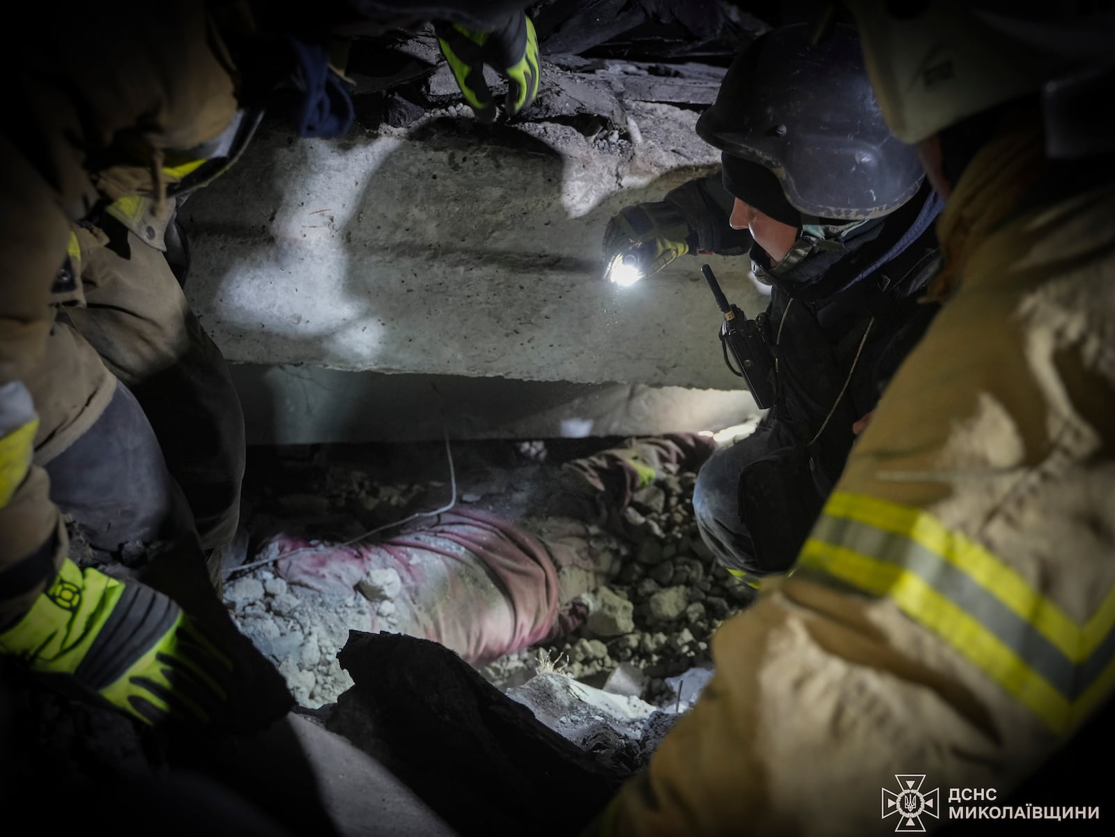 In this photo provided by the Ukrainian Emergency Service, rescuers unblock the body of a civilian who was killed when a Russian drone hit a city food factory in Mykolaiv, Ukraine, Wednesday, Jan. 29, 2025. (Ukrainian Emergency Service via AP)