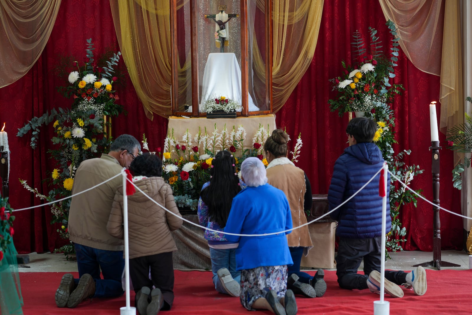 Worshippers pray before a replica of the Black Christ of Esquipulas the day before its feast day in Esquipulas Palo Gordo, in Guatemala's San Marcos department, Tuesday, Jan. 14, 2025. (AP Photo/Moises Castillo)