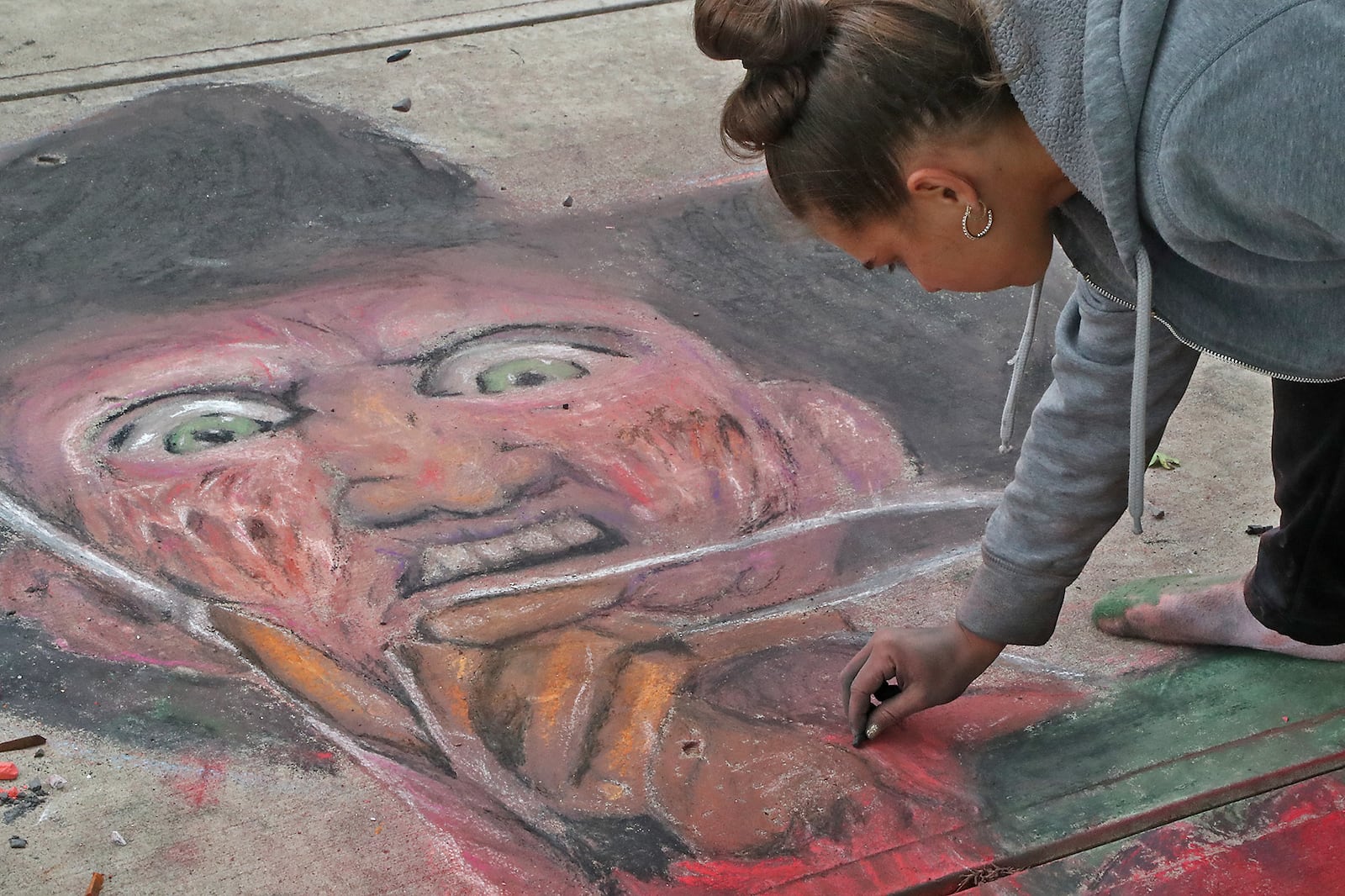 Jacee Hamilton works on her chalk artwork during the National Trail Parks and Recreation District's annual ChalkFest Saturday, Oct. 1, 2022 at National Road Commons Park. BILL LACKEY/STAFF