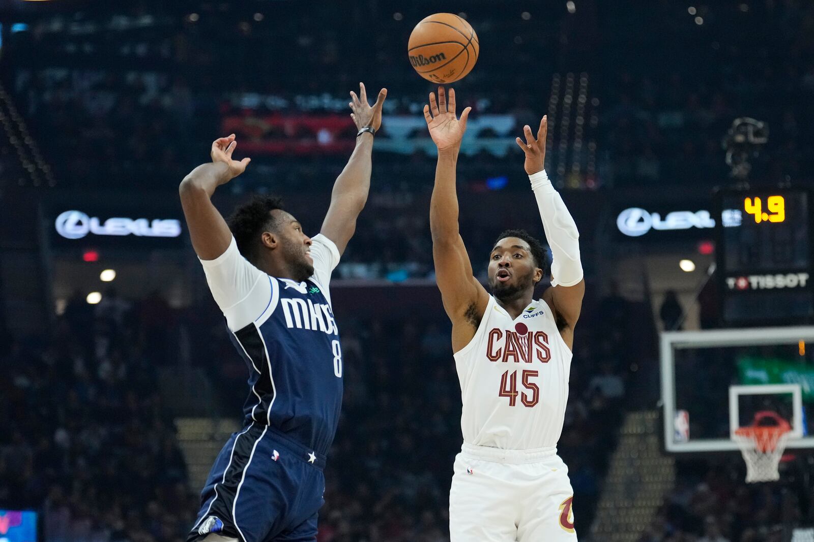 Cleveland Cavaliers guard Donovan Mitchell (45) shoots a 3-point basket over Dallas Mavericks forward Olivier-Maxence Prosper (8) in the first half of an NBA basketball game, Sunday, Feb. 2, 2025, in Cleveland. (AP Photo/Sue Ogrocki)