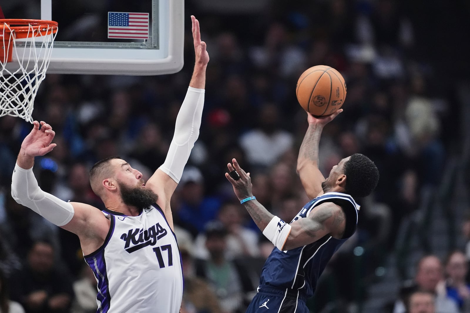 Sacramento Kings' Jonas Valanciunas (17) defeds as Dallas Mavericks' Kyrie Irving, right, looks to shoot in the first half of an NBA basketball game in Dallas, Monday, March 3, 2025. (AP Photo/Tony Gutierrez)