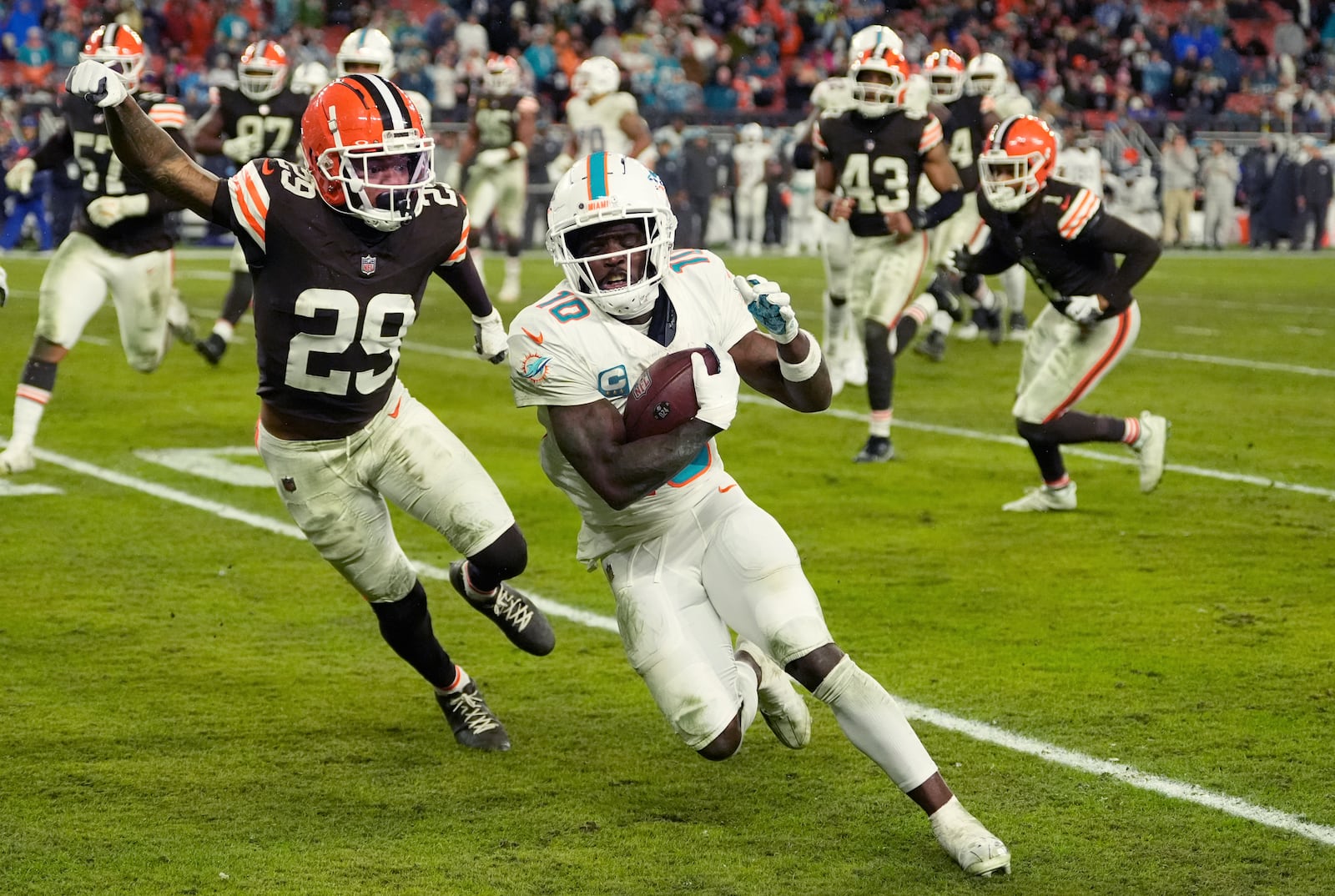 Miami Dolphins wide receiver Tyreek Hill (10) runs as Cleveland Browns cornerback Cameron Mitchell (29) defends during the second half of an NFL football game Sunday, Dec. 29, 2024, in Cleveland. (AP Photo/Sue Ogrocki)