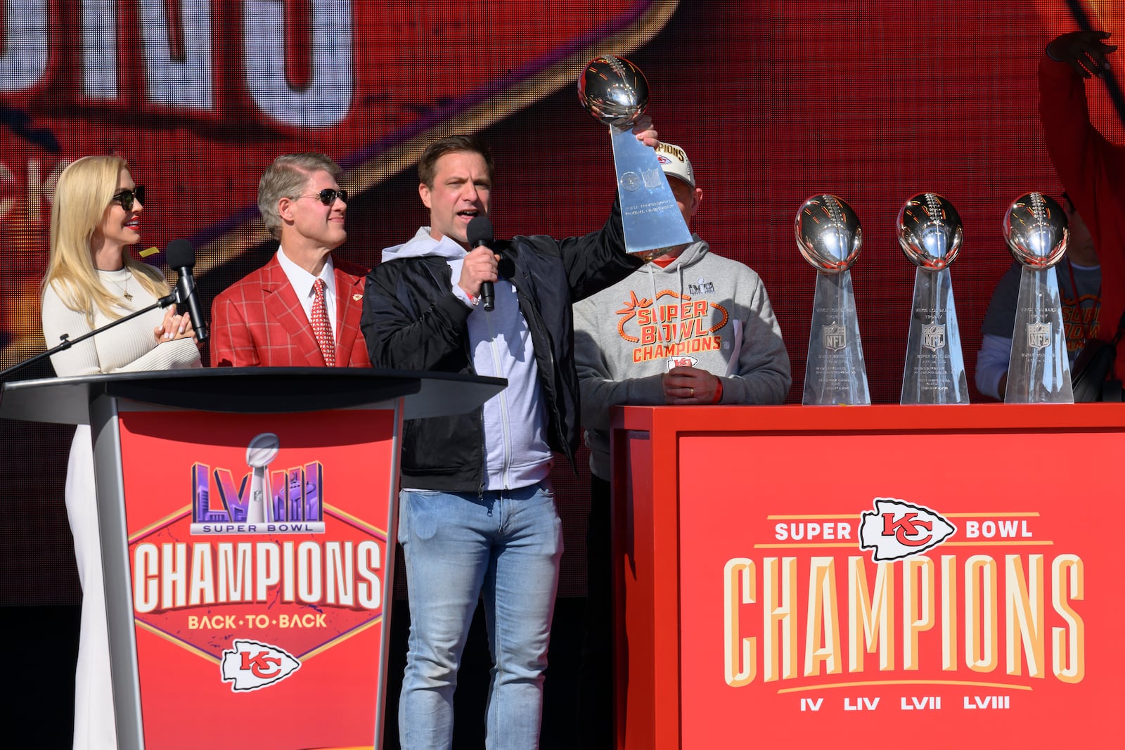 FILE - Kansas City Chiefs general manager Brett Veach, with Chiefs chairman and CEO Clark Hunt and his wife Tavia, left, introduces the crowd to the team's four Vince Lombardi Trophies during their victory rally in Kansas City, Mo., Wednesday, Feb. 14, 2024. The Chiefs defeated the San Francisco 49ers Sunday in the NFL Super Bowl 58 football game. (AP Photo/Reed Hoffmann)