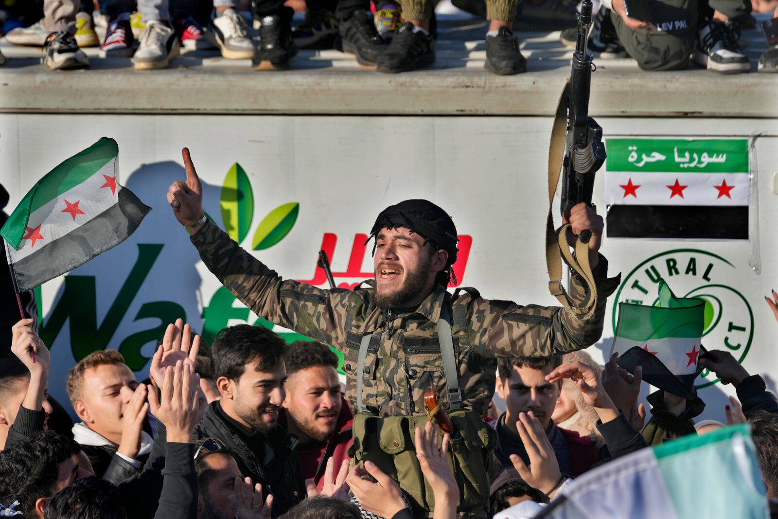 A Syrian member of the rebel group celebrates during a demonstration following the first Friday prayers since Bashar Assad's ouster, in Damascus' central square, Syria, on Friday, Dec. 13, 2024. (AP Photo/Hussein Malla)