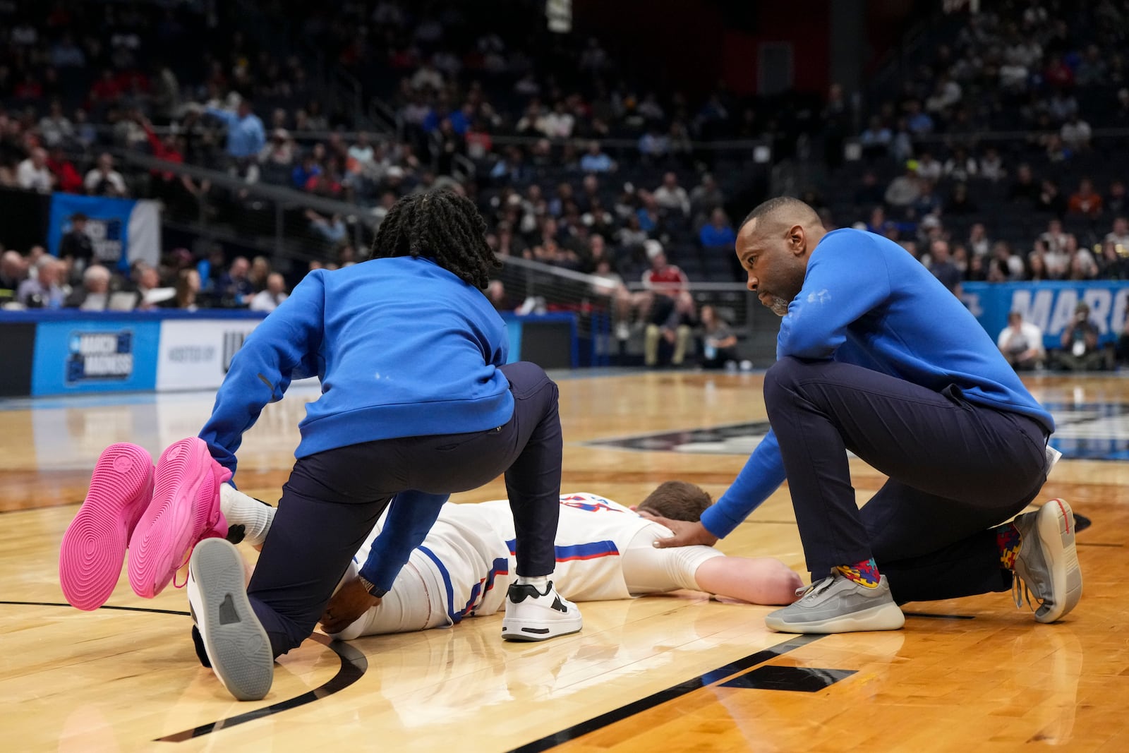 American University head coach Duane Simpkins, right, comforts player Matt Rogers after an injury during the first half of a First Four college basketball game against Mount St. Mary's in the NCAA Tournament, Wednesday, March 19, 2025, in Dayton, Ohio. (AP Photo/Jeff Dean)