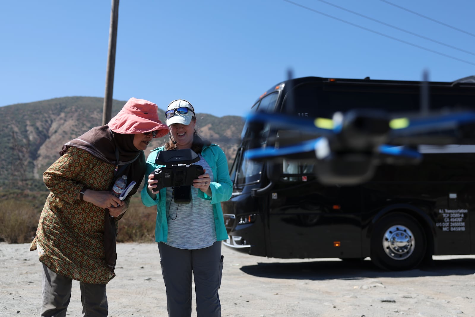 Bushra Hussaini, who works at the American Museum of Natural History, stands with Anita Marshall, a geoscience researcher at the University of Florida, as they operate a drone used to help others survey the San Andreas Fault during an accessible field trip organized by the International Association of Geoscience Diversity Thursday, Sept. 26, 2024, in San Bernadino, Calif. (AP Photo/Ryan Sun)