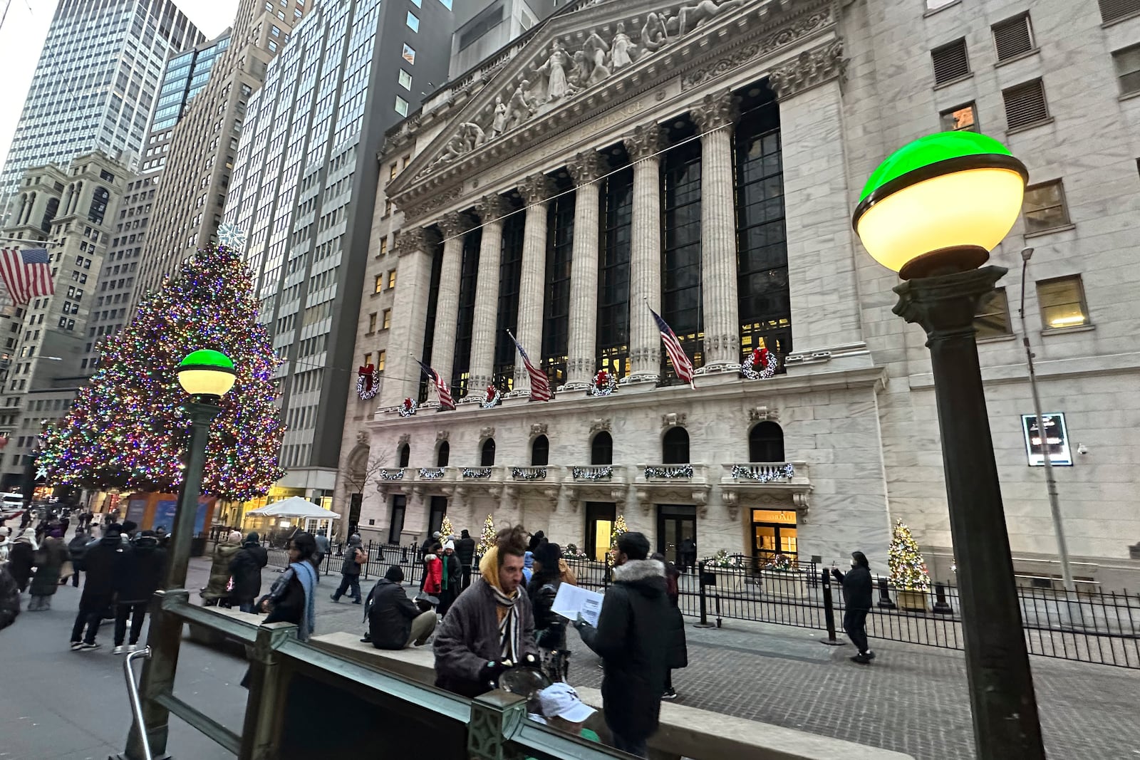 Lights marking the entrance to a subway station frame the New York Stock Exchange in New York's Financial District on Monday, Dec. 23, 2024. (AP Photo/Peter Morgan)