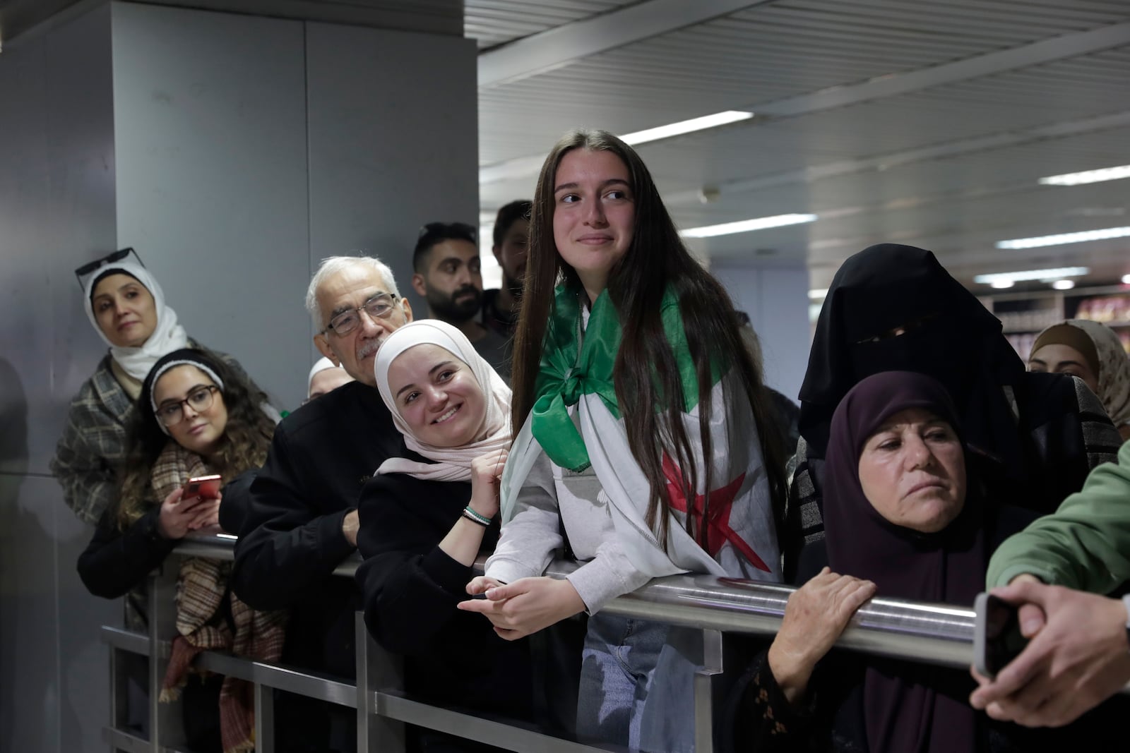 People wait to receive their relatives at the arrival terminal, after a first international commercial flight since the fall of former Syrian President Bashar Assad landed at Damascus international airport, in Damascus, Syria, Tuesday, Jan. 7, 2025. (AP Photo/Omar Sanadiki)