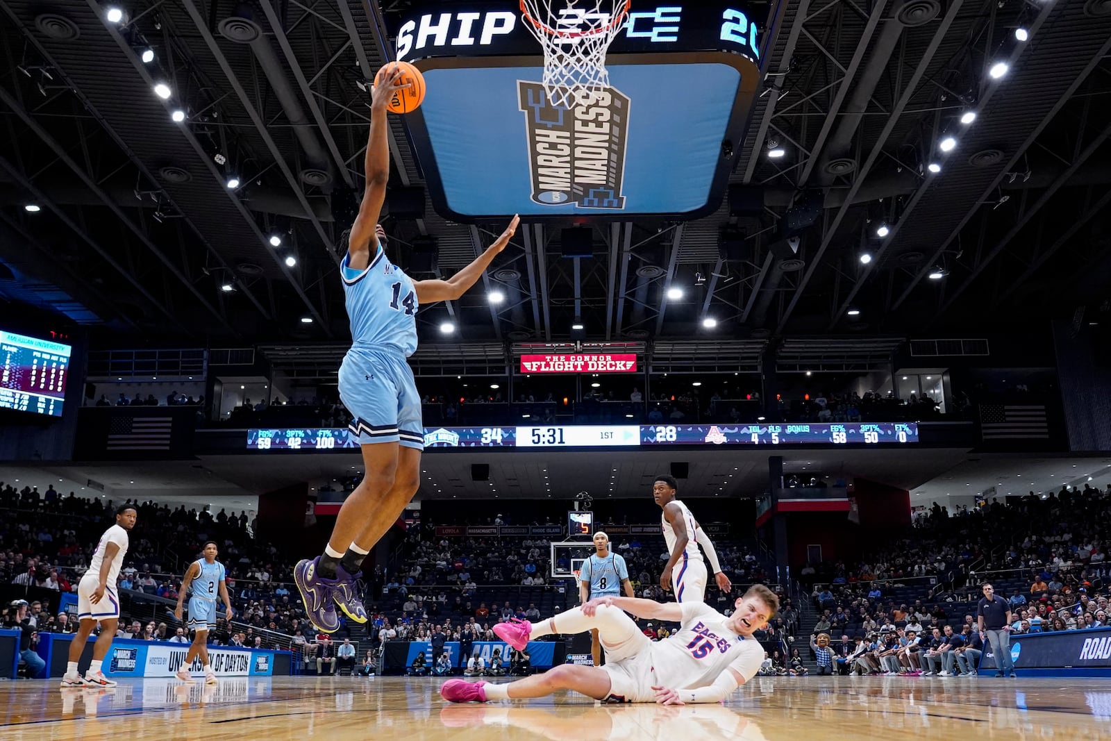 American University forward Matt Rogers (15) reacts to an injury as Mount St. Mary's forward Jedy Cordilia (14) shoots during the first half of a First Four college basketball game in the NCAA Tournament, Wednesday, March 19, 2025, in Dayton, Ohio. (AP Photo/Jeff Dean)