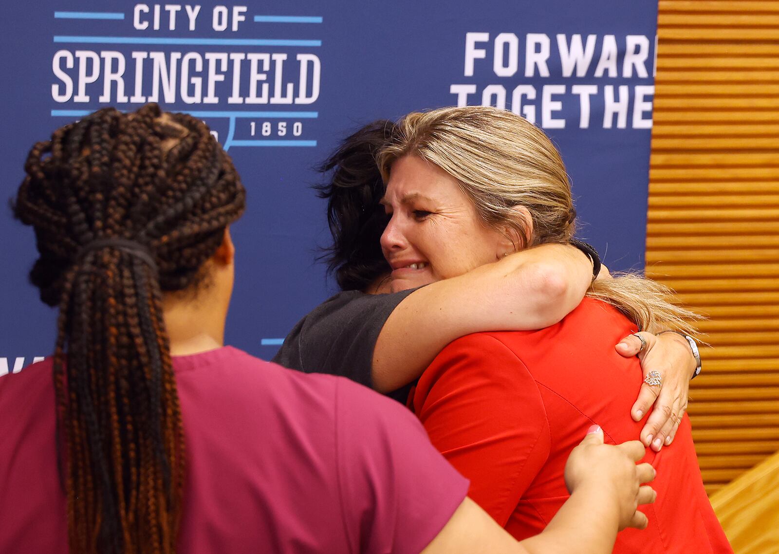 Springfield City Commissioner Tracey Tachett fights back tears as she's hugged by a resident following the city commission's voting not to enter into a agreement with Homefull to operate the Executive Inn homeless shelter during a special meeting Monday, August 5, 2024. BILL LACKEY/STAFF