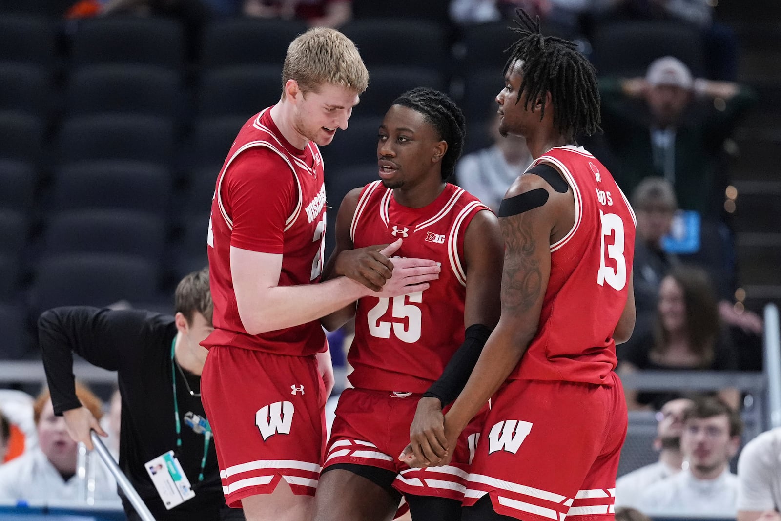 Wisconsin guard John Blackwell (25) reacts with Steven Crowl, left, and Xavier Amos (13) during the first half of an NCAA college basketball game against Michigan State in the semifinals of the Big Ten Conference tournament in Indianapolis, Saturday, March 15, 2025. (AP Photo/Michael Conroy)