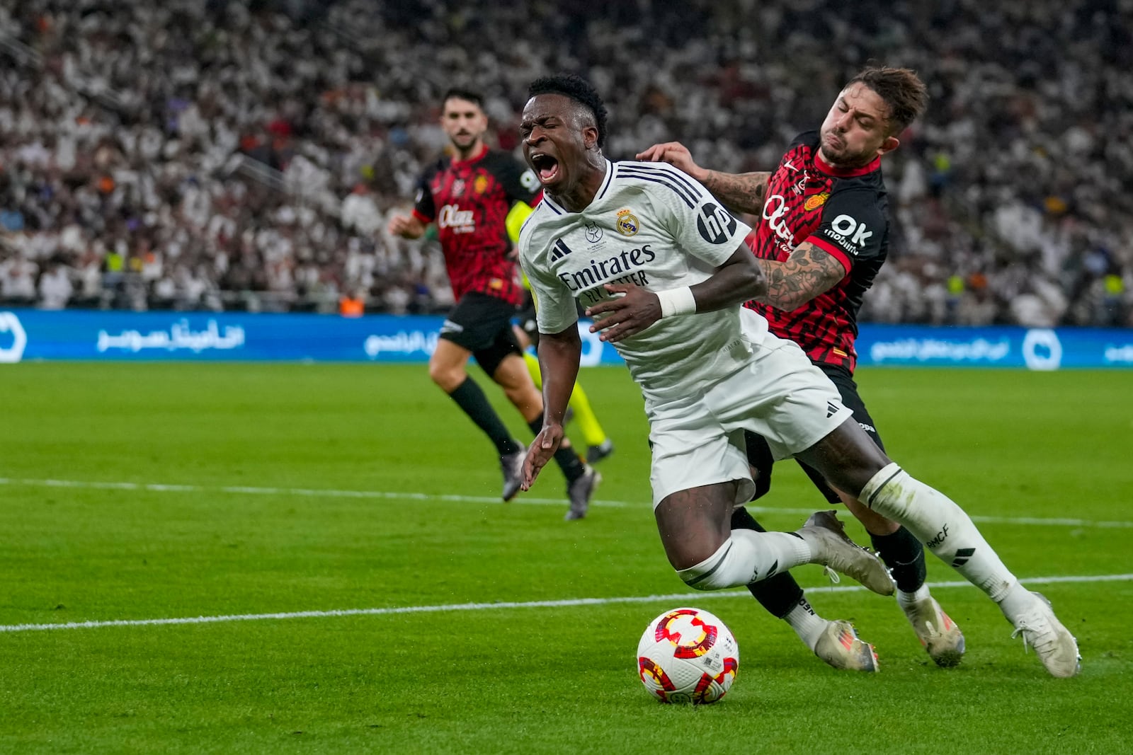 Real Madrid's Rodrygo is challenged by Mallorca's Pablo Maffeo, right, during the Spanish Super Cup semifinal soccer match between Real Madrid and Mallorca at the King Abdullah Stadium in Jeddah, Saudi Arabia, Thursday, Jan. 9, 2025. (AP Photo/Altaf Qadri)