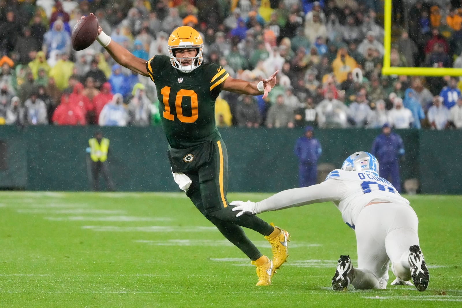 Green Bay Packers quarterback Jordan Love (10) runs around Detroit Lions defensive end Pat O'Connor (95) during the second half of an NFL football game Sunday, Nov. 3, 2024, in Green Bay, Wis. (AP Photo/Morry Gash)