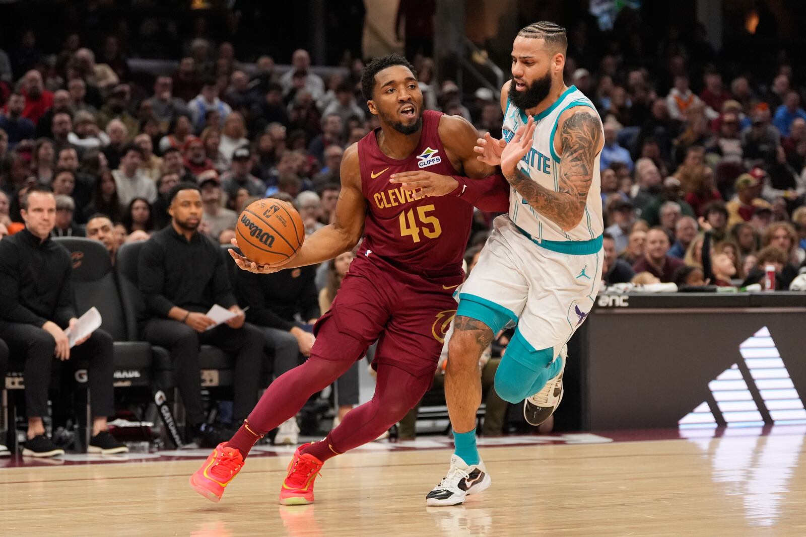 Cleveland Cavaliers guard Donovan Mitchell (45) drives past Charlotte Hornets forward Cody Martin, right, in the first half of an NBA basketball game, Sunday, Jan. 5, 2025, in Cleveland. (AP Photo/Sue Ogrocki)