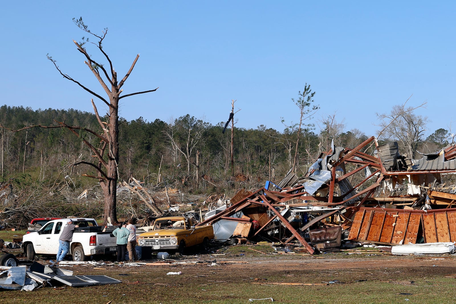 Residents look for personal belongings in the damage after a tornado passed through where two people lost their lives, Sunday, March 16, 2025, in Plantersville, Ala. (AP Photo/Butch Dill)