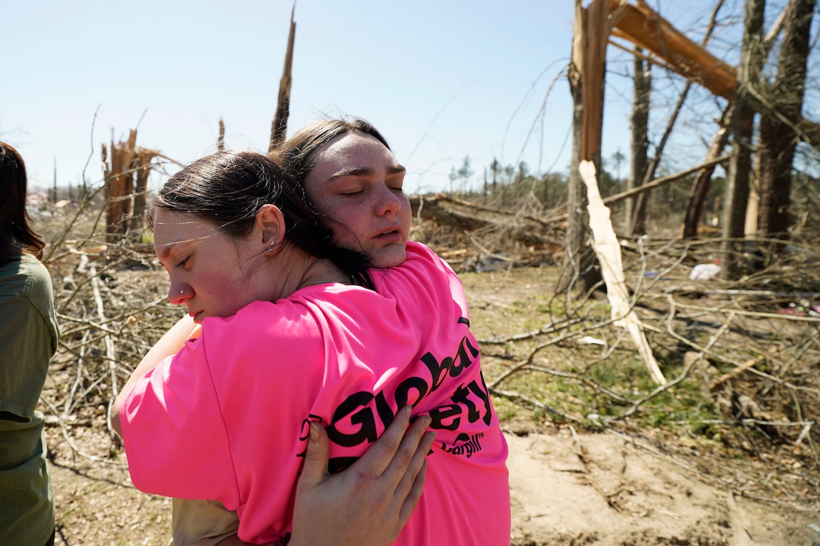 Hailey Hart, 21, right, hugs a friend, Sage Falgoust, 16, after recalling how she, her fiancee and their dogs rode out Saturday's tornado in their 1994 Toyota automobile, Sunday, March 16, 2025, in Tylertown, Miss. (AP Photo/Rogelio V. Solis)