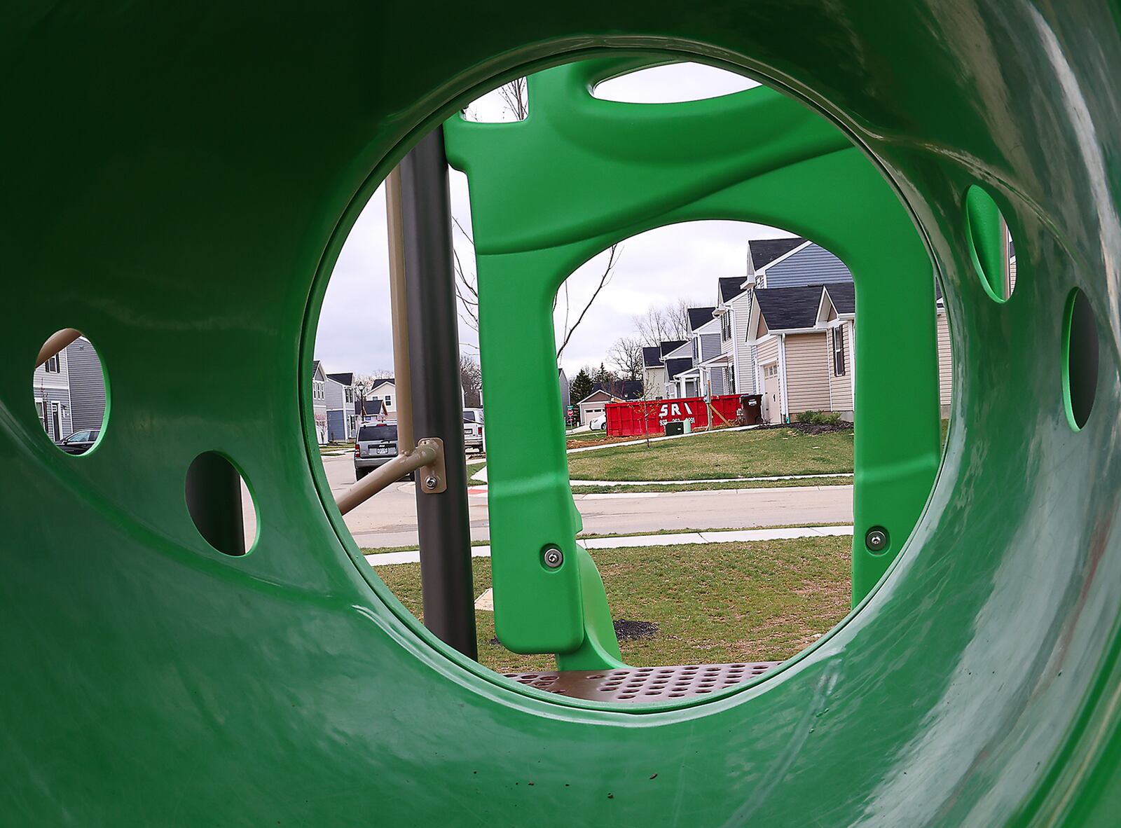 Houses in the Bridgewater development are seen through playground equipment at a playground for the kids in the development Friday, April 8, 2022. BILL LACKEY/STAFF