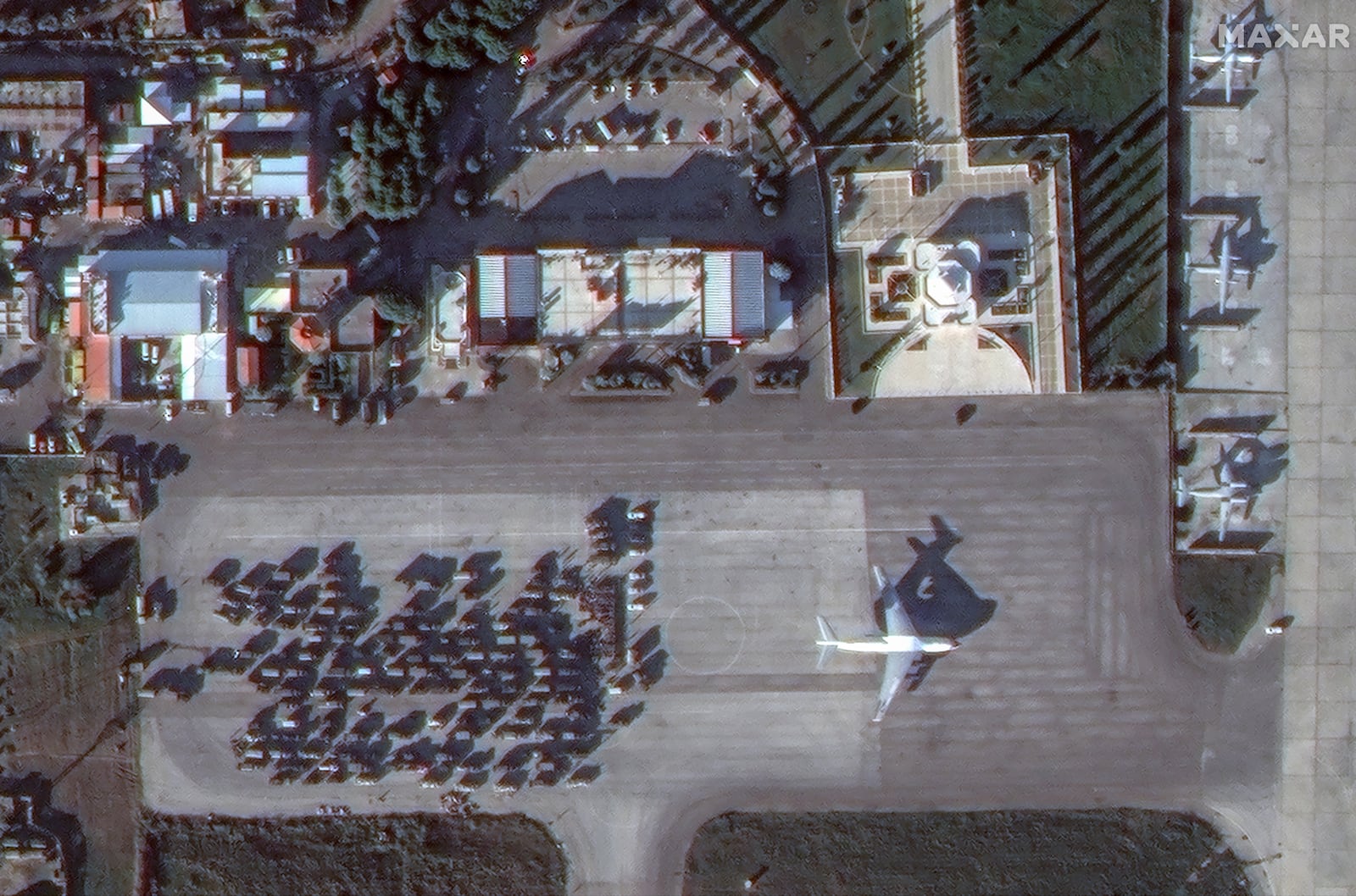 This satellite image taken on Dec. 15 and released by Maxar Technologies on Tuesday, Dec. 17, 2024 shows Russian transport aircraft and military vehicles assembled on tarmac at the Khmeimim airbase, near Latakia, Syria. (Maxar Technologies via AP)