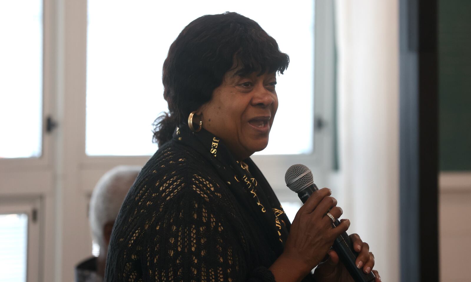 Tobi Cooper speaks at a service held in honor of her husband, Michael Cooper Sr., of Springfield, on Sunday, May 21, at Trinity Community in Fairborn. David Jablonski/Staff