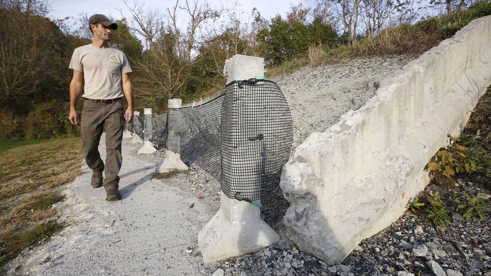 Spring Valley Wildlife Area manager Brant Fulks walks past a bullet-pocked backstop at the Spring Valley Shooting Range. The range was closed in October for improvements that include a new entrance and road off Houston Road. The work is expected to be completed in late 2019. TY GREENLEES / STAFF