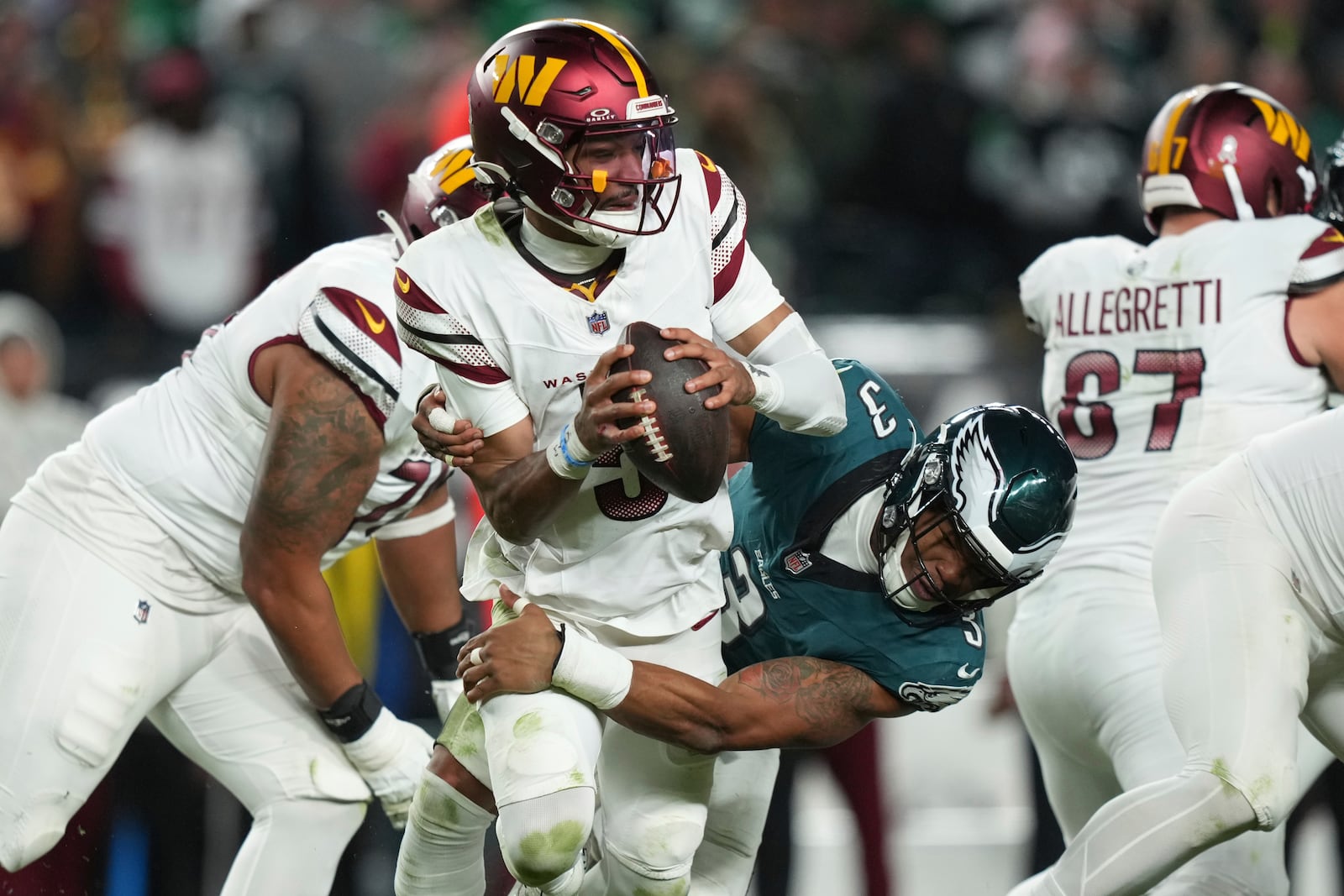 Washington Commanders quarterback Jayden Daniels (5) is sacked by Philadelphia Eagles linebacker Nolan Smith Jr. (3) during the second half of an NFL football game Thursday, Nov. 14, 2024, in Philadelphia. (AP Photo/Matt Slocum)