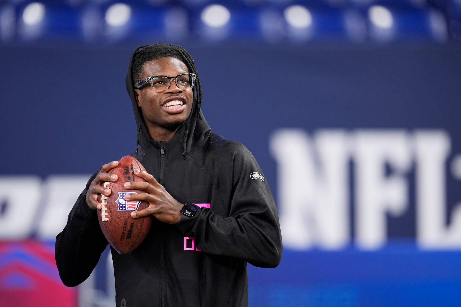 Colorado defensive back Travis Hunter tosses a football as he watches drills at the NFL football scouting combine in Indianapolis, Friday, Feb. 28, 2025. (AP Photo/George Walker IV)