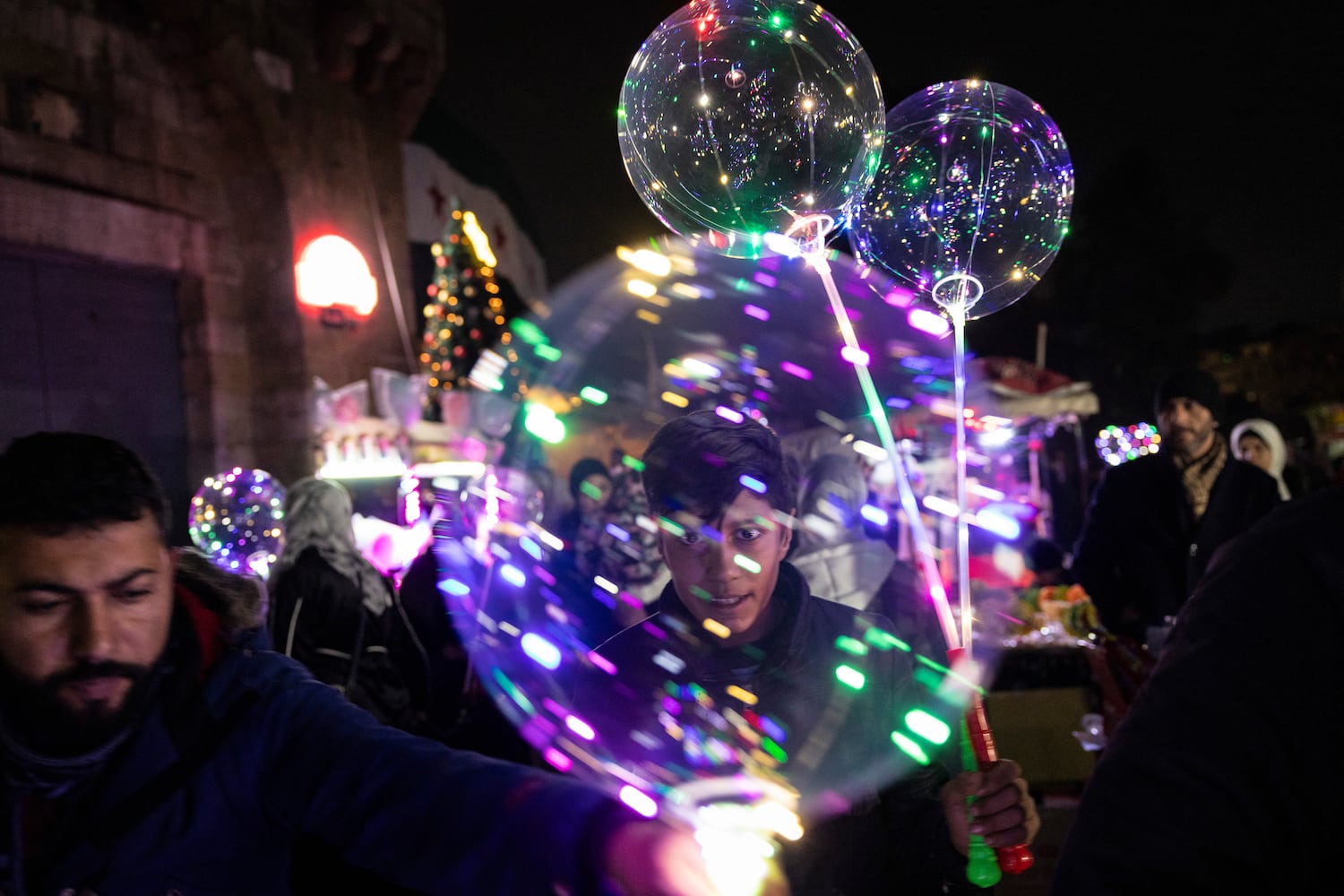 People carry lighted balloons to celebrate on New Year’s Eve in Damascus, Syria, on Tuesday, Dec. 31, 2024. (David Guttenfelder/The New York Times)