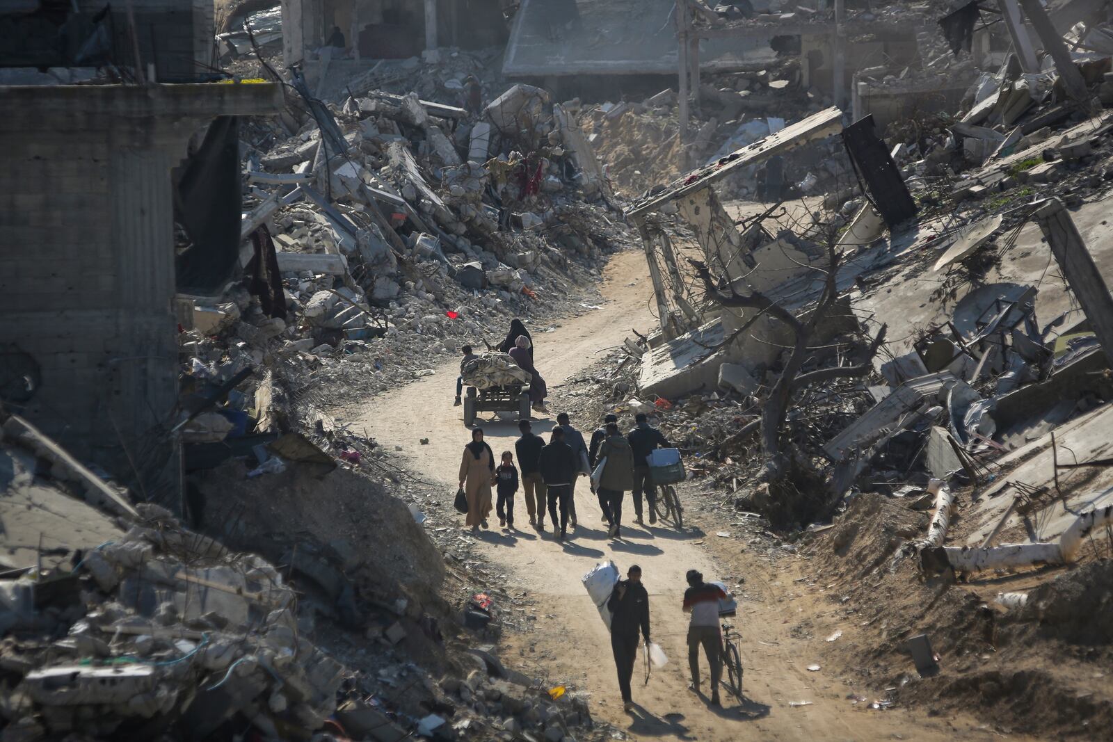 Palestinians who have returned walk among the rubble of buildings largely destroyed by Israeli army bombardments in Beit Lahia, northern Gaza Strip, Wednesday, Jan. 29, 2025, after Israel began allowing hundreds of thousands of Palestinians to return to the heavily damaged area last Monday.(AP Photo/Jehaid Alshrafi)