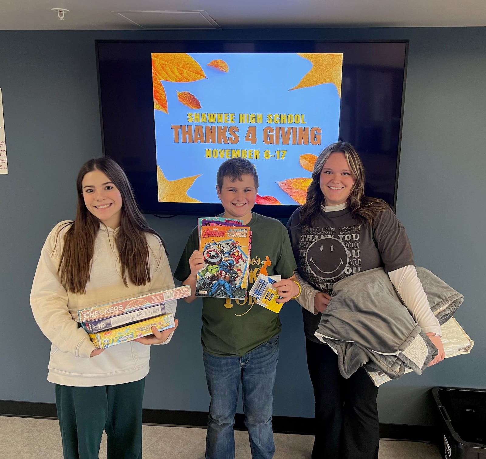 Shawnee High School is hosting a Thanks 4 Giving donation drive for staff and students to bring in items to donate to two local organizations who provide resources and support to Clark County residents. In this photo is Olivia Lemon (right), Reese Chilcote (left) and Evan Brown (middle). Contributed