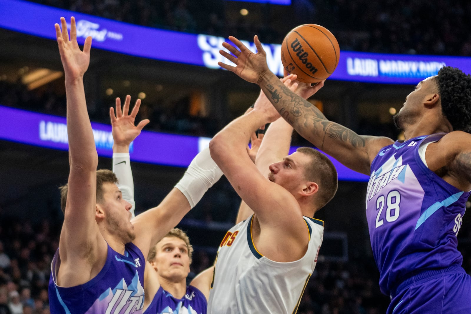 Denver Nuggets center Nikola Jokic, second from right, shoots as Utah Jazz center Walker Kessler, left, forward Lauri Markkanen, second from left, and forward Brice Sensabaugh (28) defend during the first half of an NBA basketball game Monday, Dec. 30, 2024, in Salt Lake City. (AP Photo/Rick Egan)