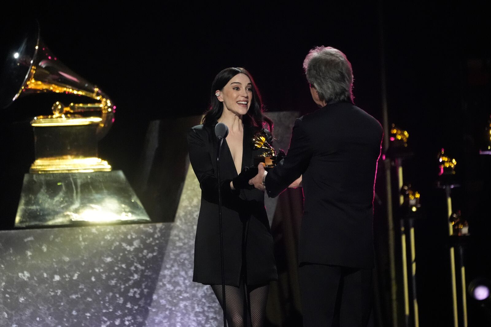 St. Vincent, left, accepts the award for best alternative music album for "All Born Screaming" from Bob Clearmountain during the 67th annual Grammy Awards on Sunday, Feb. 2, 2025, in Los Angeles. (AP Photo/Chris Pizzello)