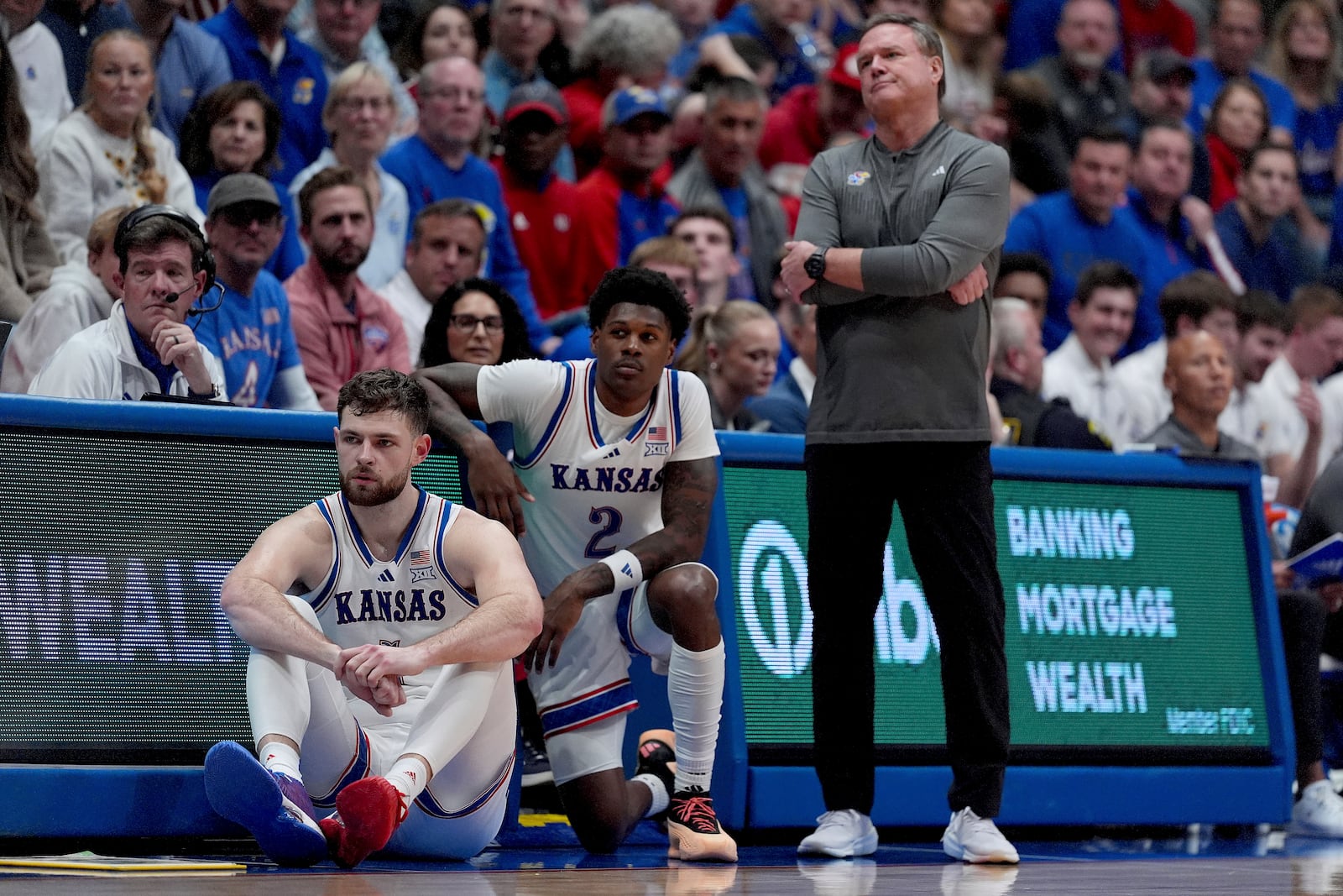 Kansas head coach Bill Self watches with center Hunter Dickinson, left, and guard AJ Storr (2) during the second half of an NCAA college basketball game against UNC Wilmington, Tuesday, Nov. 19, 2024, in Lawrence, Kan. (AP Photo/Charlie Riedel)