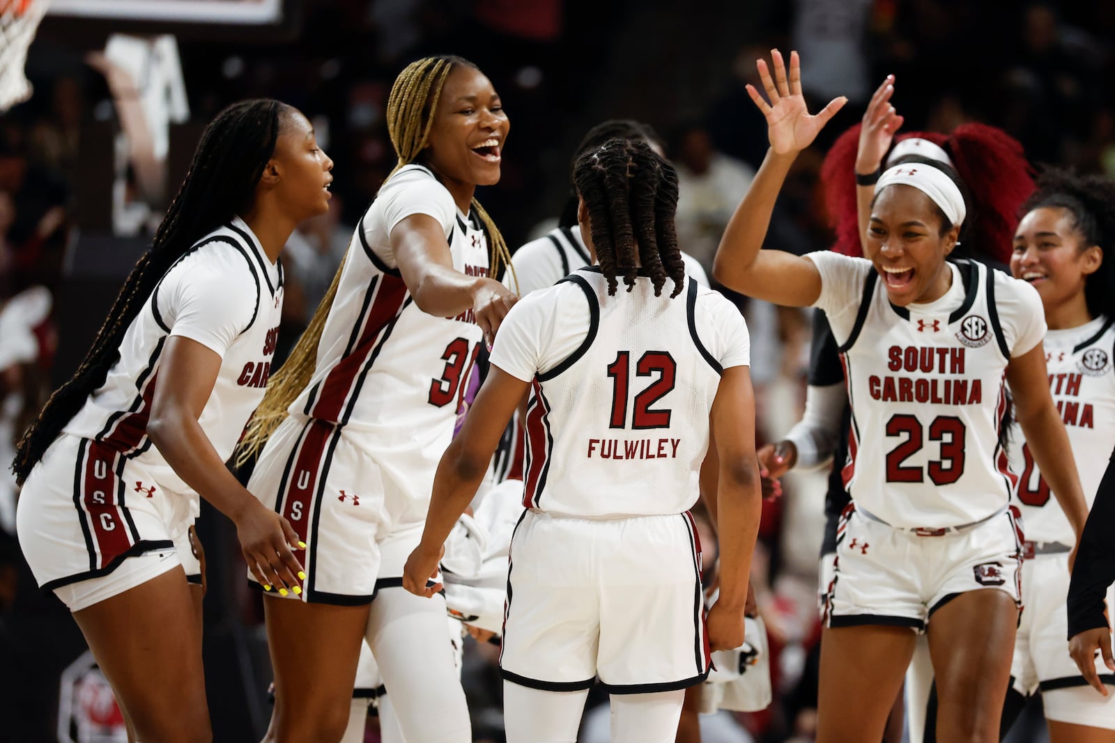 South Carolina forward Joyce Edwards, left, forward Maryam Dauda (30) and guard Bree Hall (23) celebrate with guard MiLaysia Fulwiley (12) after Fulwiley hit a three-pointer against Oklahoma during the first half of an NCAA college basketball game in Columbia, S.C., Sunday, Jan. 19, 2025. (AP Photo/Nell Redmond)