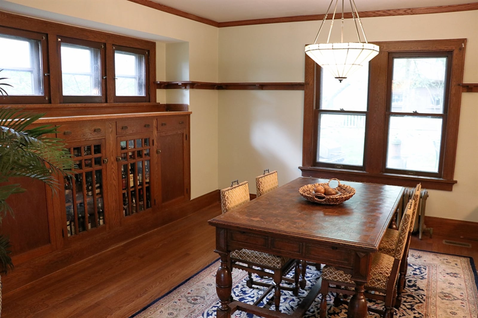 In the dining room, a built-in hutch fills an entire wall. The hutch has glass-panel and solid-wood cabinet doors as well as drawers.