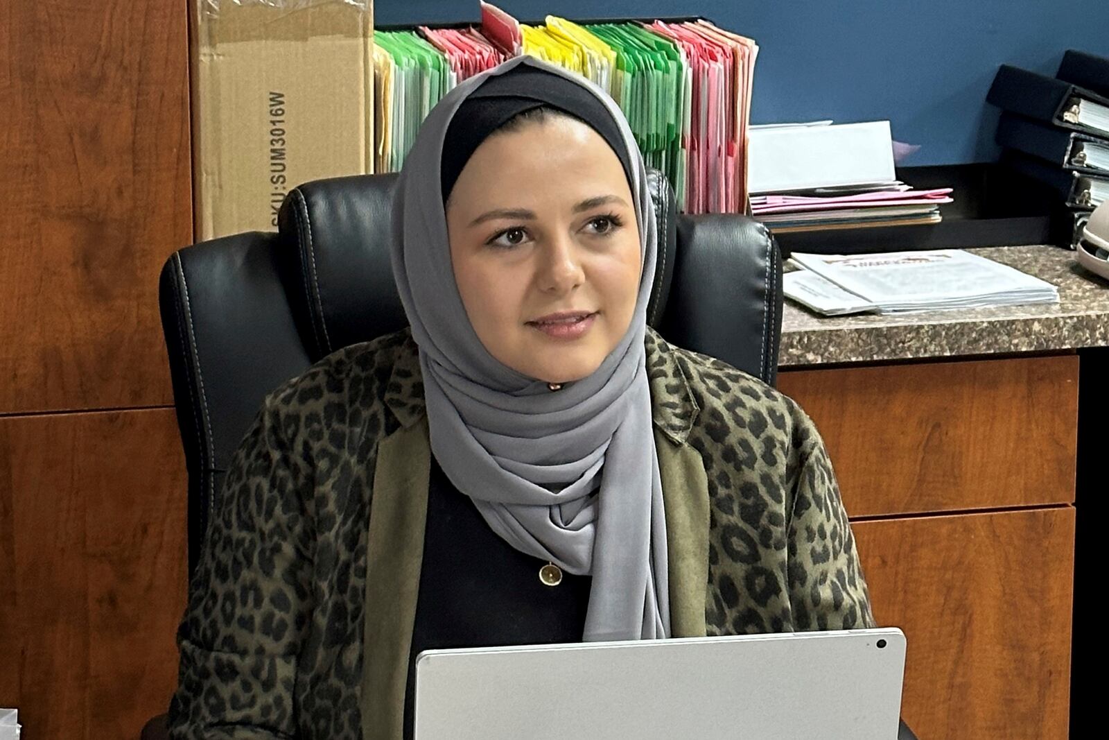 Rama Alhoussaini sits at her desk in Dearborn Heights, Mich., Tuesday, Dec. 10, 2024. (AP Photo/Corey Williams)