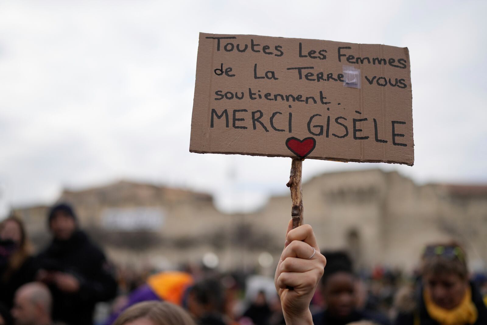 A woman holds a placard reading "All the women in the world support you. Thank you Gisele" outside the Avignon courthouse, southern France, Thursday, Dec. 19, 2024. (AP Photo/Lewis Joly)