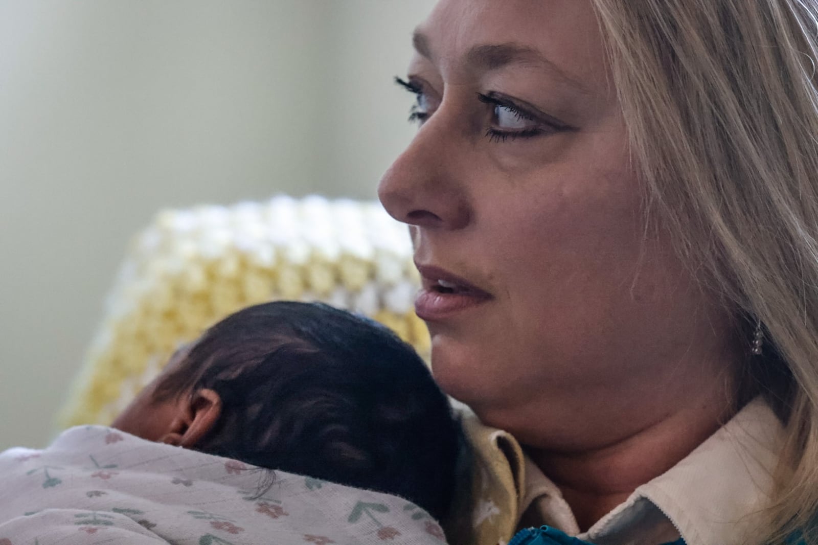 Marcy Miller, a volunteer cuddler, holds an infant at Brigid's Path in Kettering. JIM NOELKER/STAFF