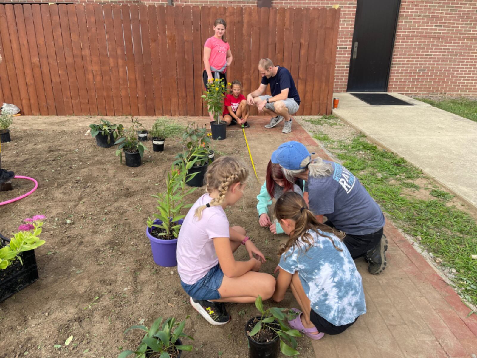 John Campbell and Pam Young help the elementary students measure the Butterfly Garden to best place the plants throughout the space. Contributed/Clark-Shawnee Local Schools