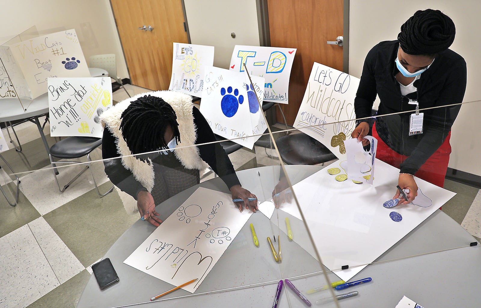 Employees at the Rocking Horse Center made signs Thursday to show their support for the Springfield Wildcats in the state football playoffs. The employees are planning to stand along South Limestone and cheer as the Wildcats leave for their game. BILL LACKEY/STAFF