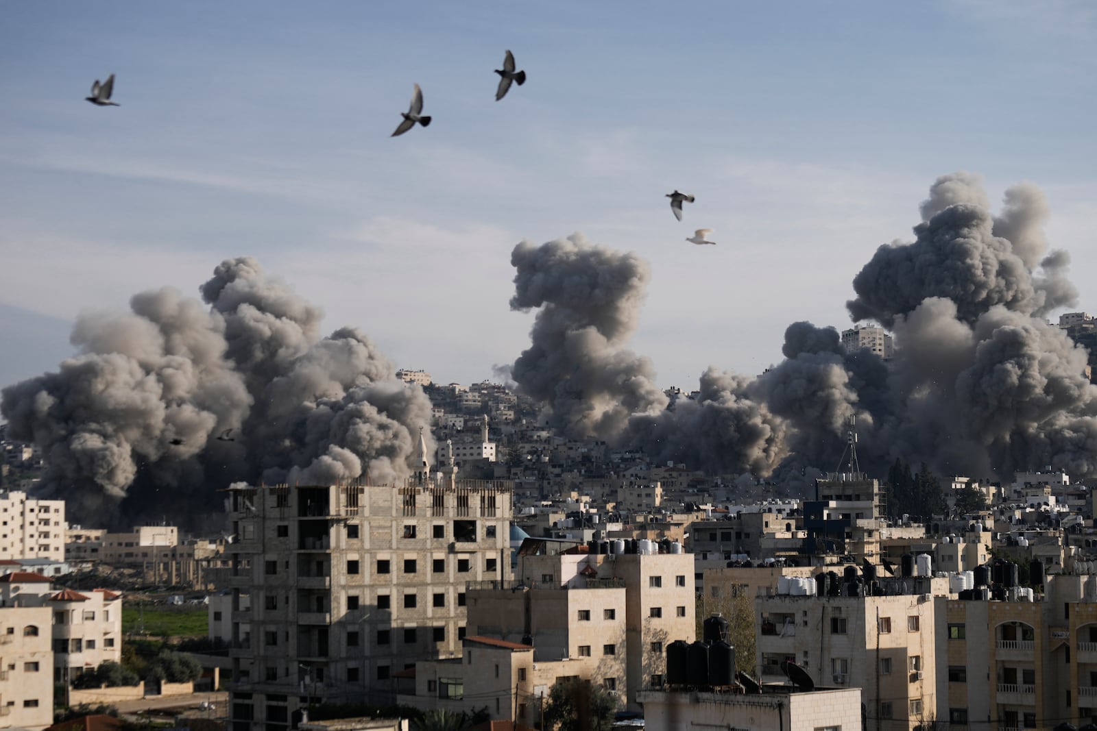 Smoke rises following an explosion detonated by the Israeli army, which said it was destroying buildings used by Palestinian militants in the West Bank Jenin refugee camp, Sunday, Feb. 2, 2025. (AP Photo/Majdi Mohammed)