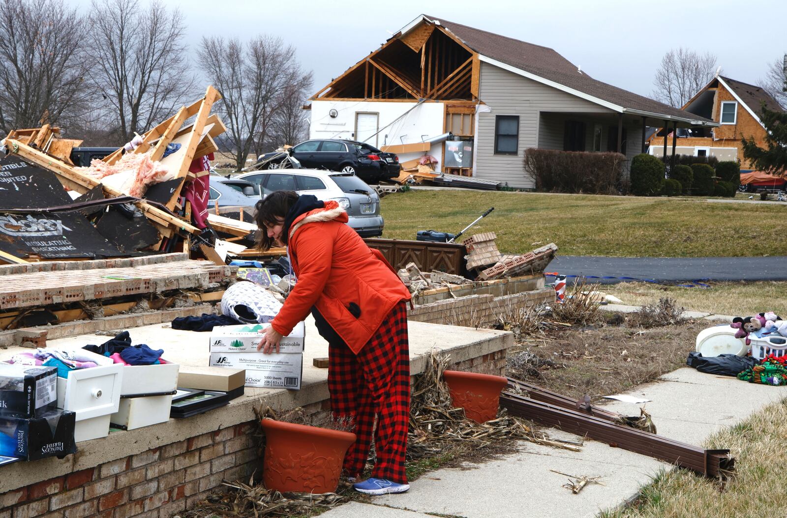 Rebekah Stewart sorts through what’s left of her families house for clothes and personal belongings Wednesday afternoon. Wednesday’s storm destroyed Rebekah’s home and severely damaged several others on Mitchell Road. BILL LACKEY/STAFF