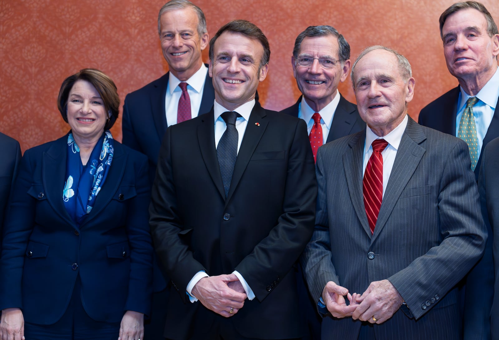 France's President Emmanuel Macron, center, is welcomed to the U.S. Capitol by, from left, Sen. Amy Klobuchar, D-Minn., Senate Majority Leader John Thune, R-S.D., Sen. John Barrasso, R-Wyo., Sen. James Risch, R-Idaho, and Sen. Mark Warner, D-Va., in Washington, Monday, Feb. 24, 2025. (AP Photo/J. Scott Applewhite)