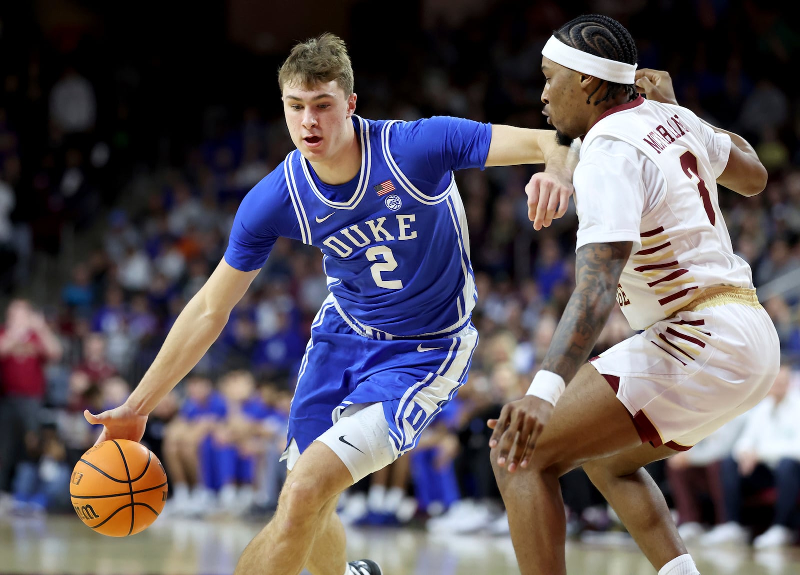 Duke guard Cooper Flagg (2) dribbles around Boston College guard Roger McFarlane (3) during the first half of an NCAA college basketball game Saturday, Jan. 18, 2025, in Boston. (AP Photo/Mark Stockwell)