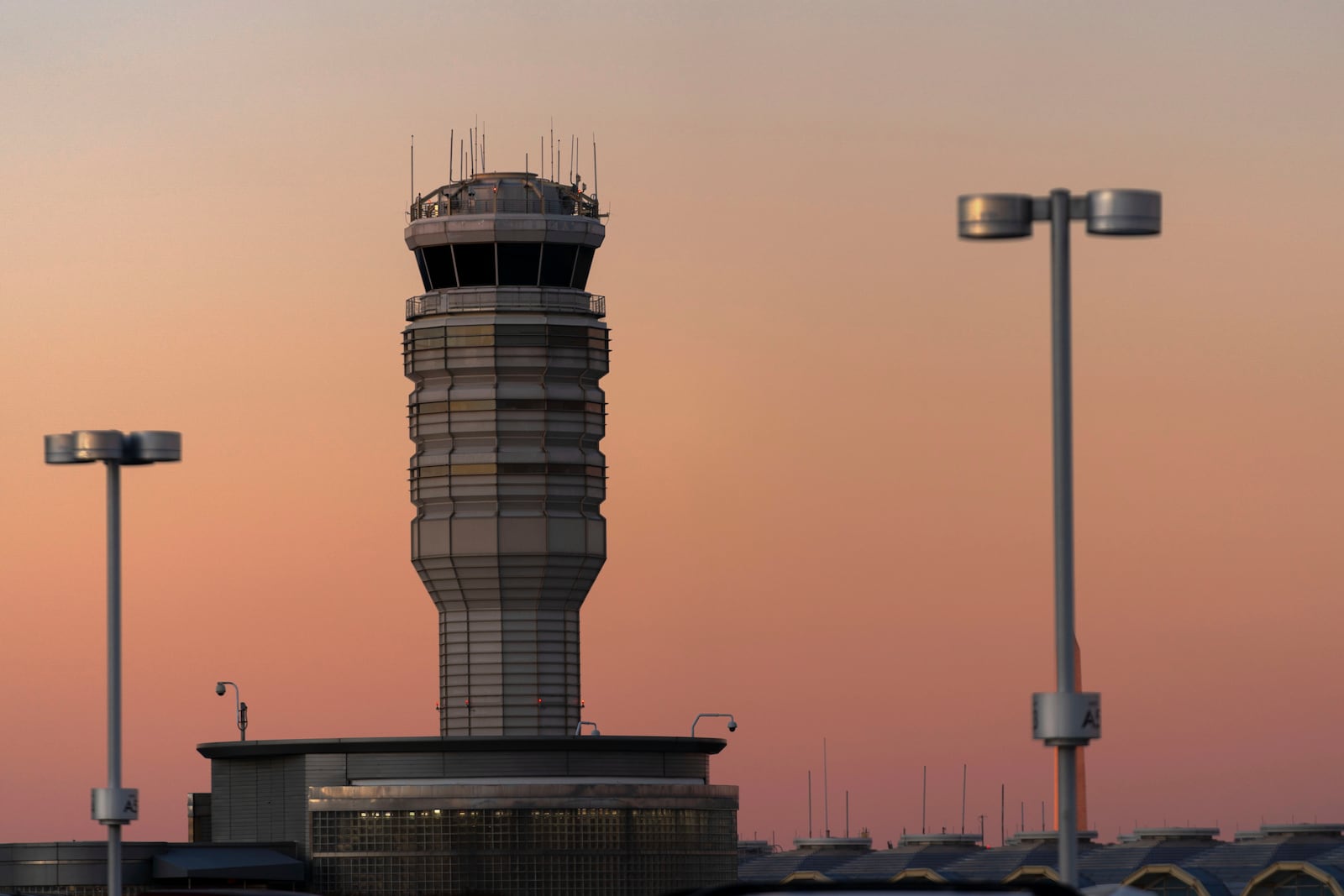 The air traffic control tower at Ronald Reagan Washington National Airport is seen at sunset, Saturday, Feb. 1, 2025, in Arlington, Va., near the wreckage of a mid-air collision between a Black Hawk helicopter and an American Airlines jet in the Potomac River. (AP Photo/Jose Luis Magana)