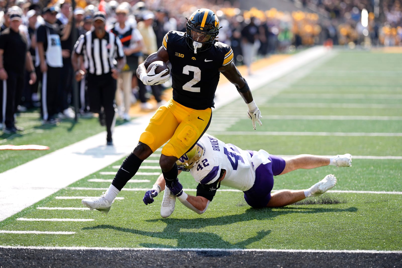 Iowa running back Kaleb Johnson (2) runs from Washington linebacker Carson Bruener (42) during an 18-yard touchdown reception in the first half of an NCAA college football game, Saturday, Oct. 12, 2024, in Iowa City, Iowa. (AP Photo/Charlie Neibergall)