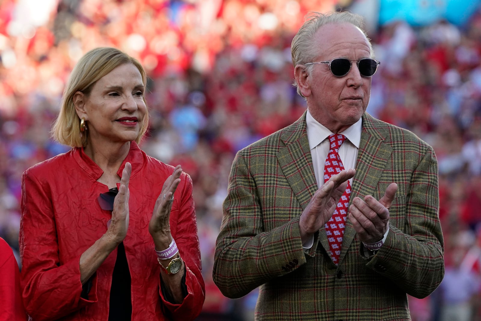 FILE - Former Mississippi and New Orleans Saints quarterback and father of former Mississippi and New York Giants quarterback Eli Manning, right and his wife Olivia Manning, applaud their son Eli, as he addresses the crowd during the retirement ceremony for his football jersey, number 10, during an NCAA college football game against LSU in Oxford, Miss., on Oct. 23, 2021. (AP Photo/Rogelio V. Solis, File)