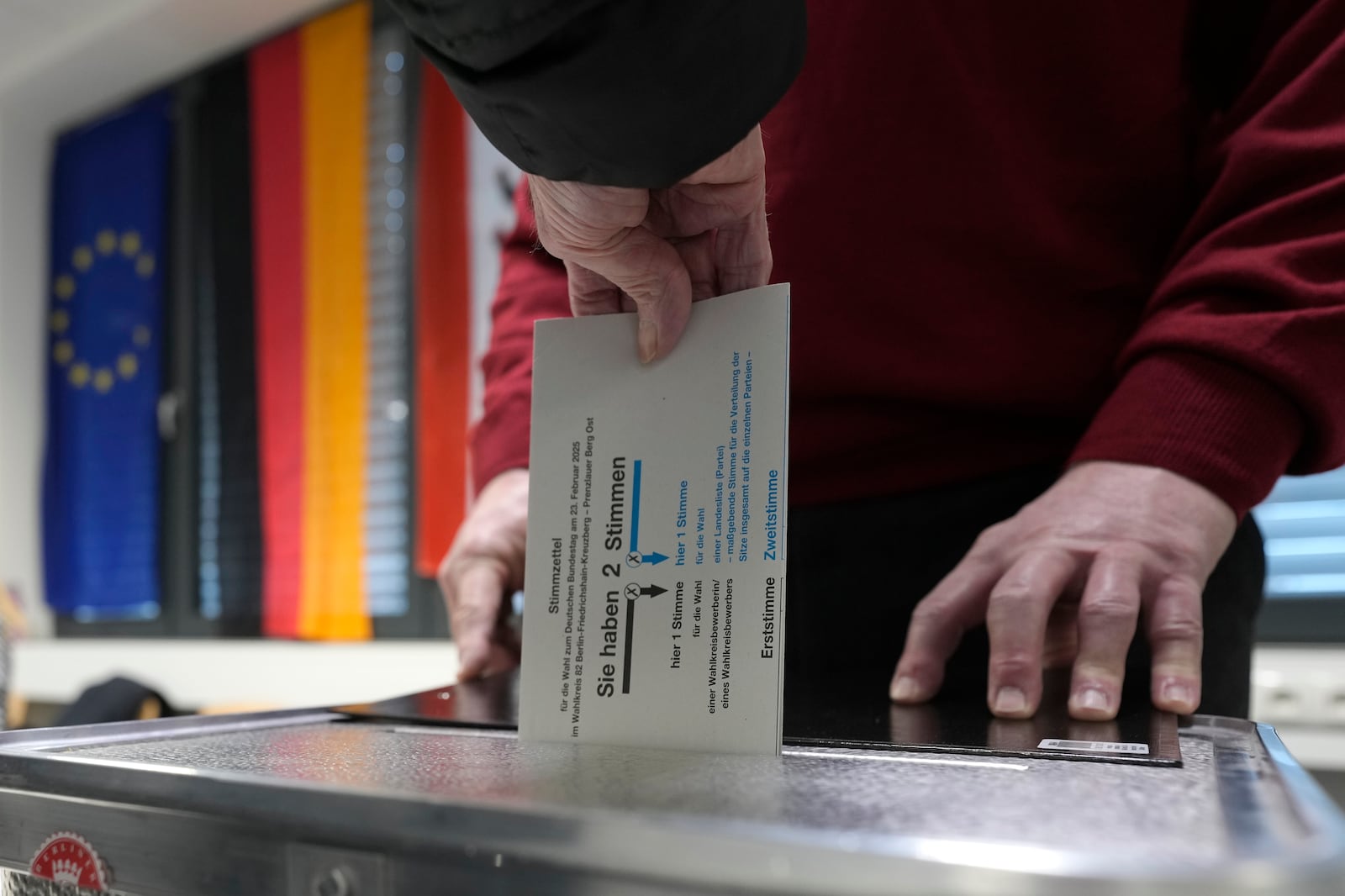 Resident casts a vote at a polling station in Berlin, Germany, Sunday, Feb. 23, 2025, during the German national election. (AP Photo/Markus Schreiber)