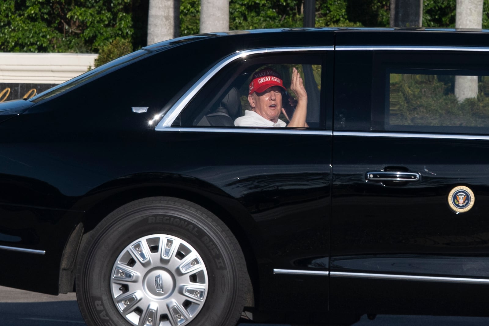 President Donald Trump waves from his limousine as he arrives at his golf club in West Palm Beach, Fla., Saturday, March 8, 2025, in West Palm Beach, Fla. (AP Photo/Manuel Balce Ceneta)